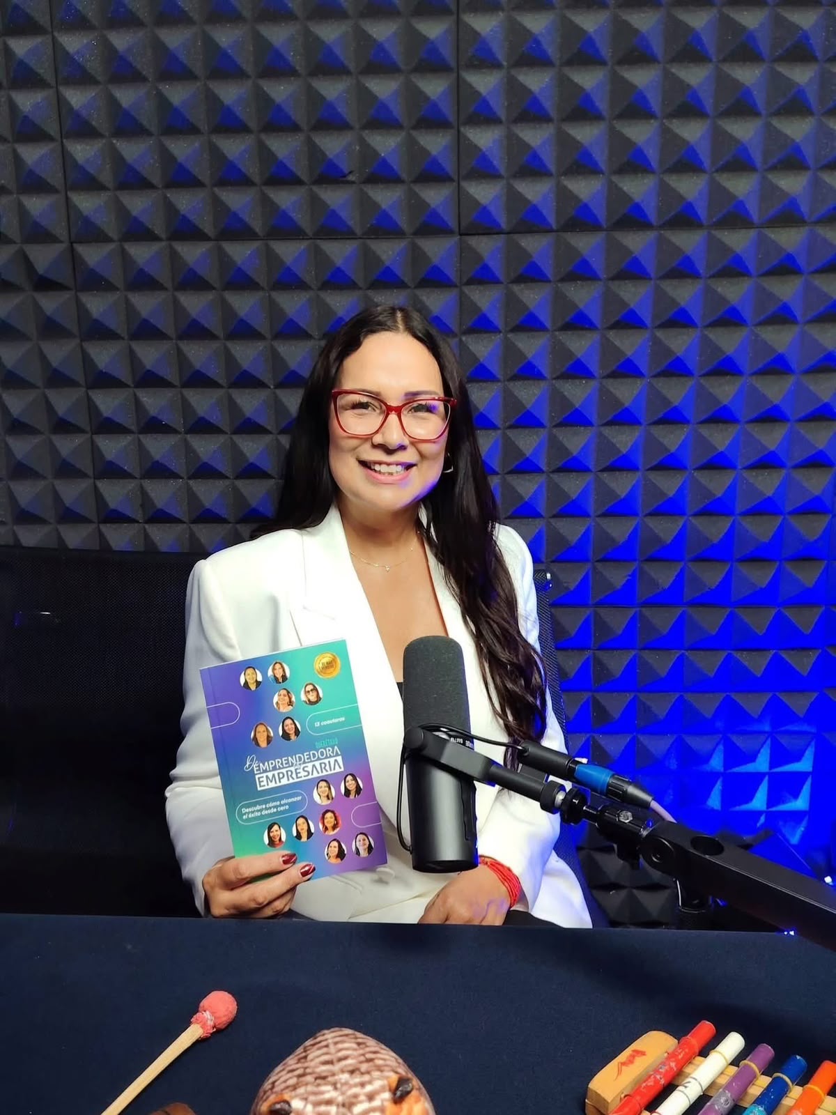 Verónica Reyna en un podcast mostrando el libro De Emprendedora a Empresaria